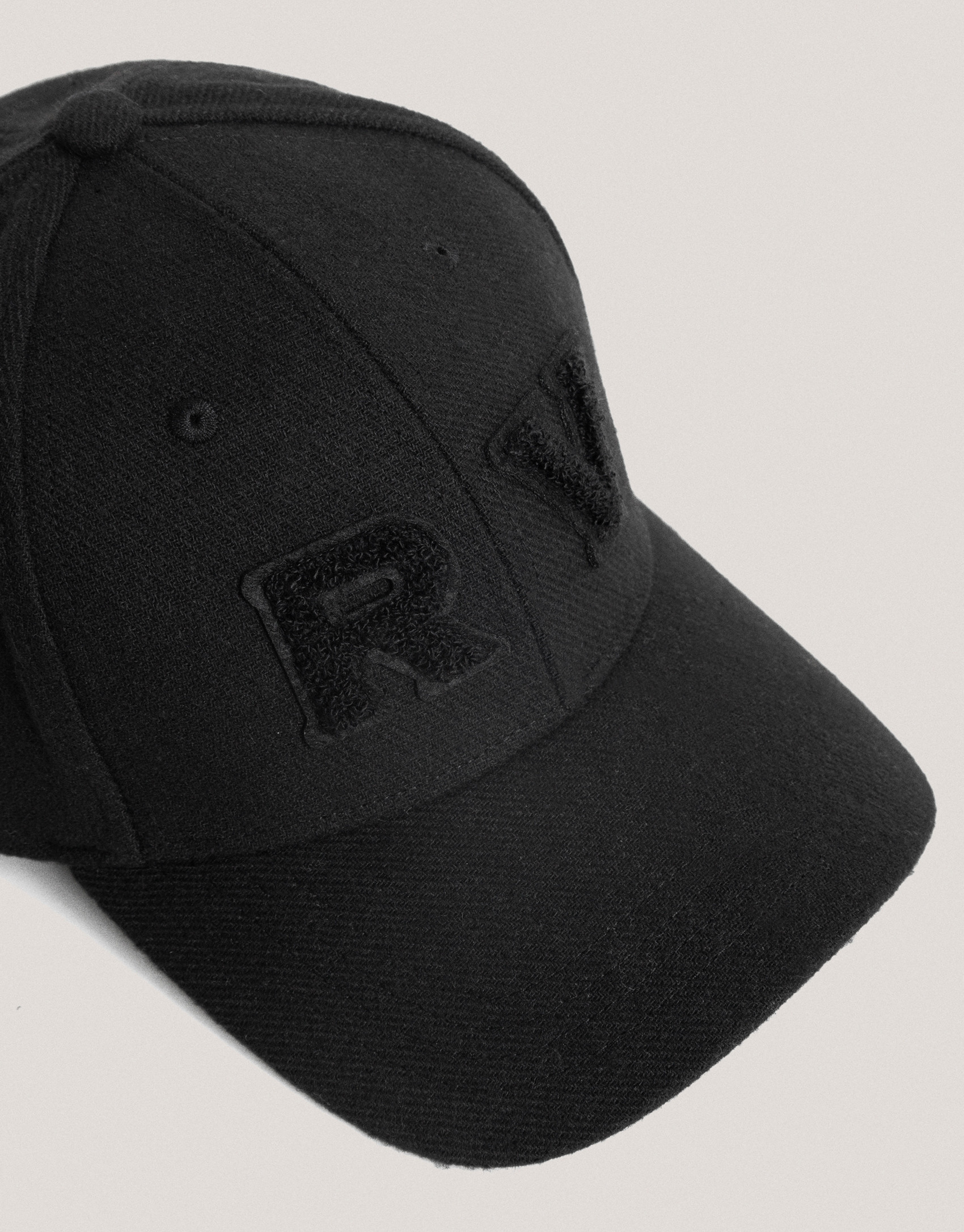 Black felt cap with visor and embossed RV logo  | Roberto Verino
