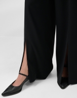 Wide-legged black crepe trousers with slit