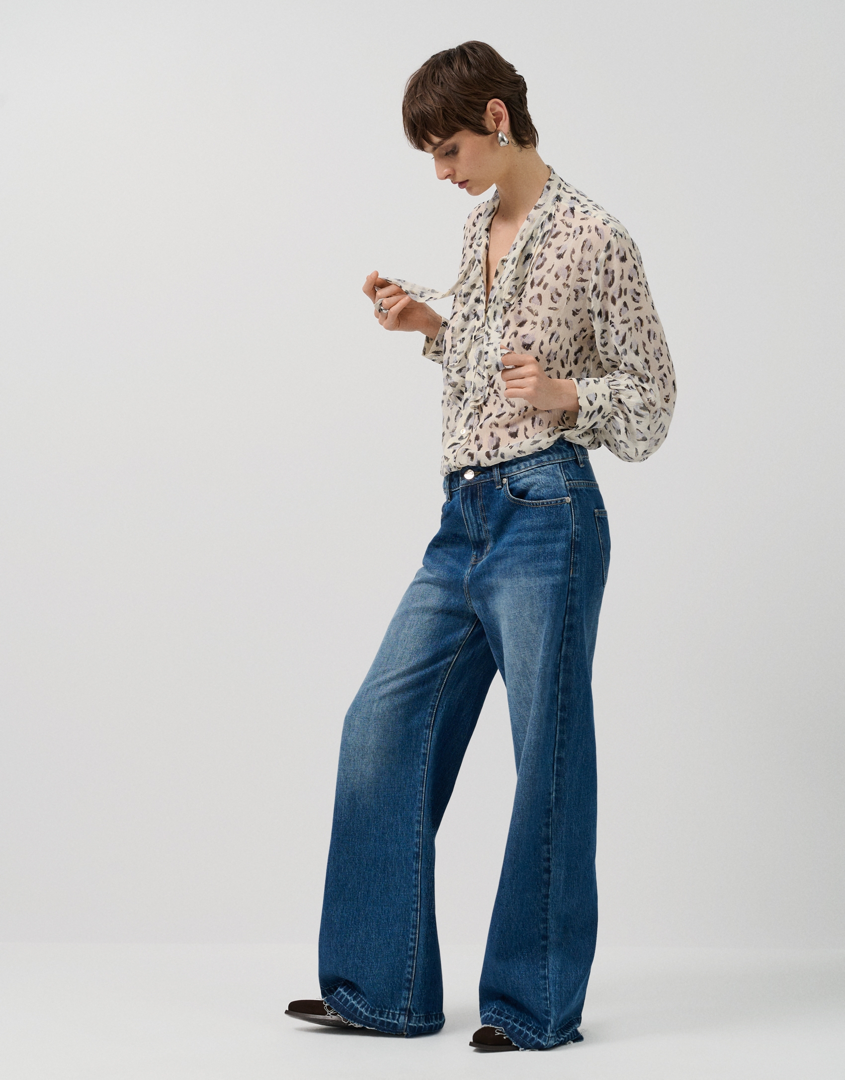Blouse with ruffles on the chest and a grey spot print