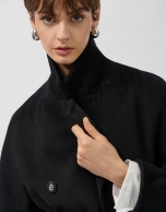 Long double-breasted coat in black cloth.