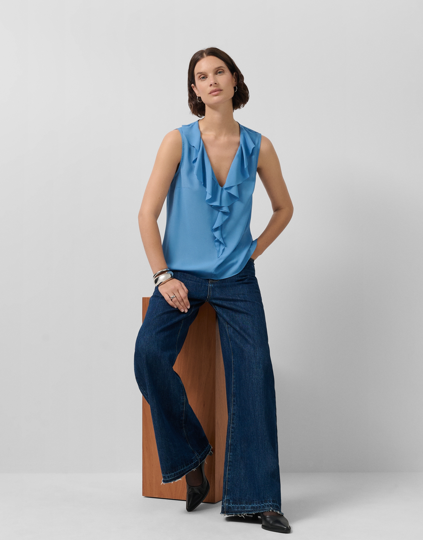 Blusa sin mangas en crepé azul con volante