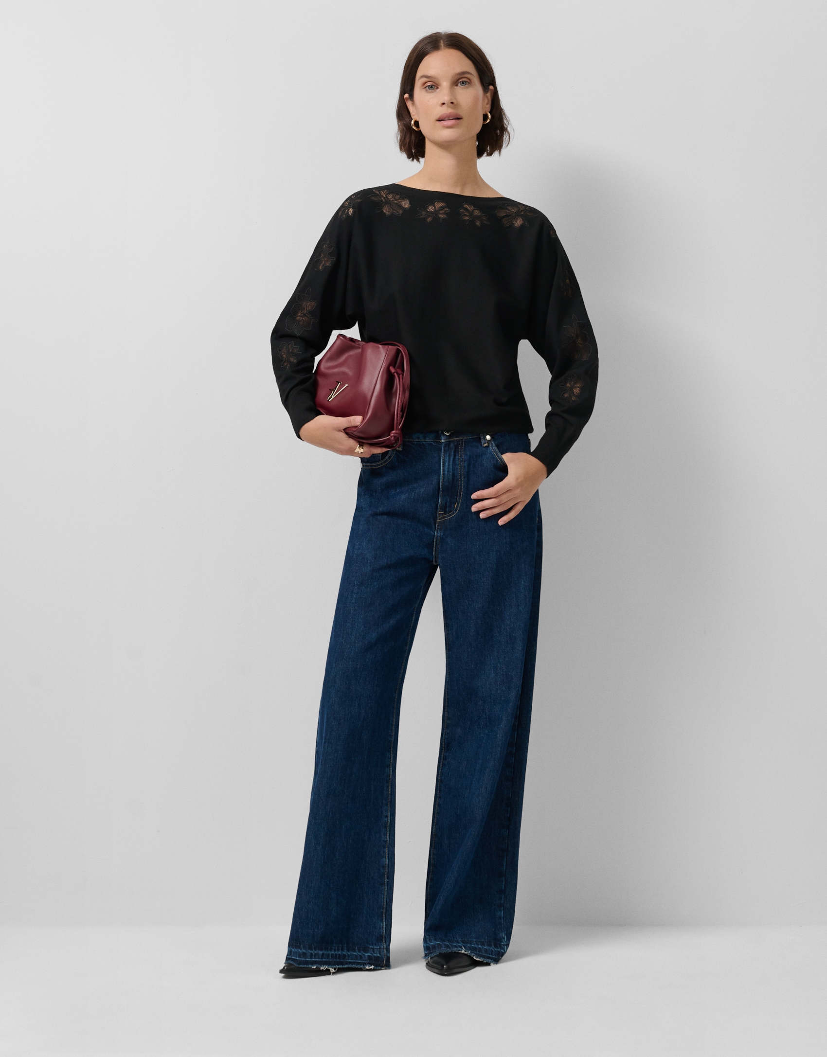 Black fine knit sweater with embroidered lace flowers on the sleeves