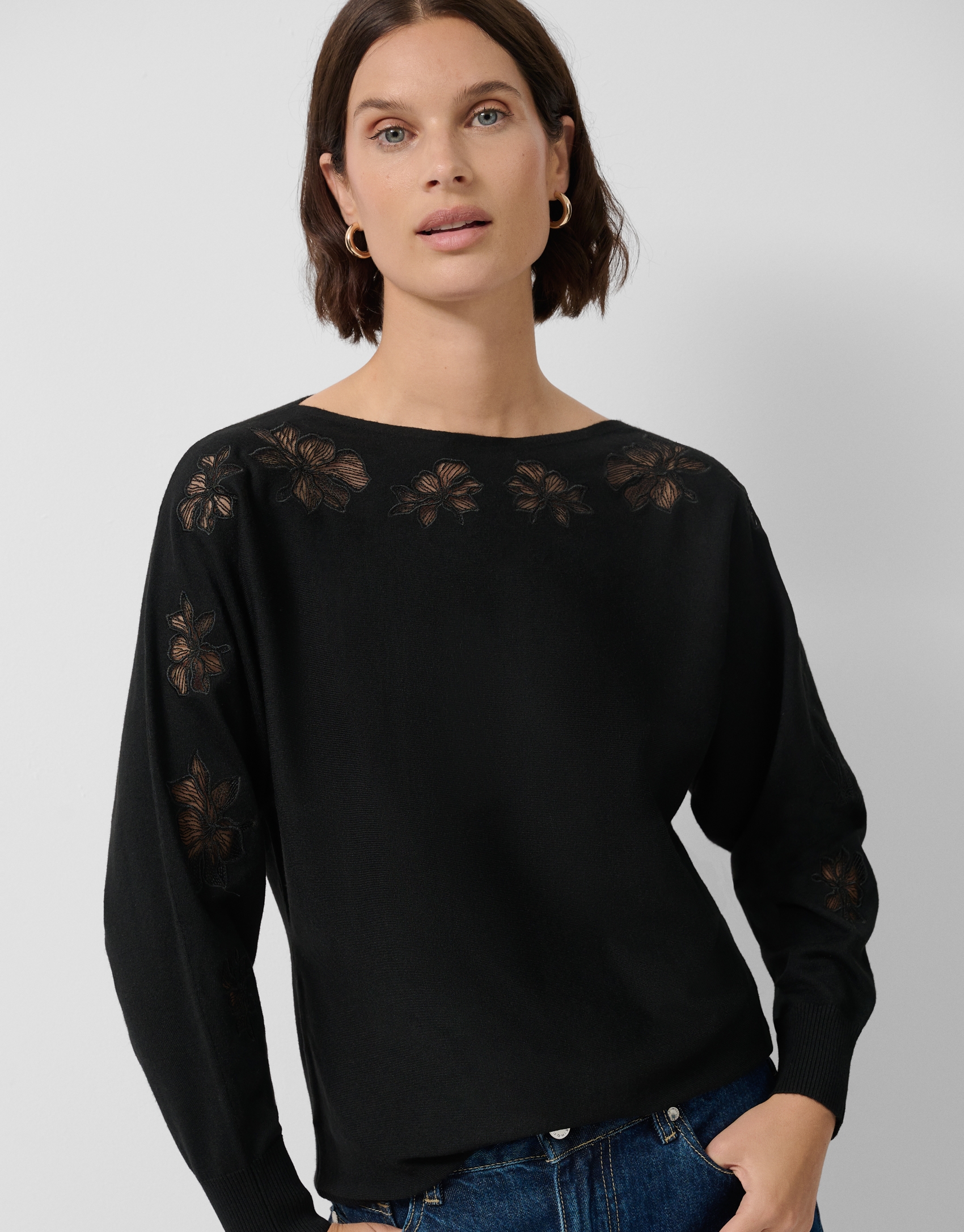 Black fine knit sweater with embroidered lace flowers on the sleeves