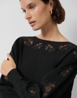 Jersey punto fino negro con flores de encaje bordadas en mangas
