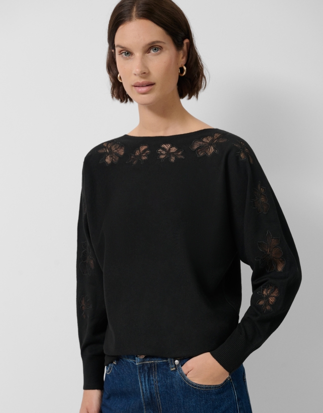 Jersey punto fino negro con flores de encaje bordadas en mangas