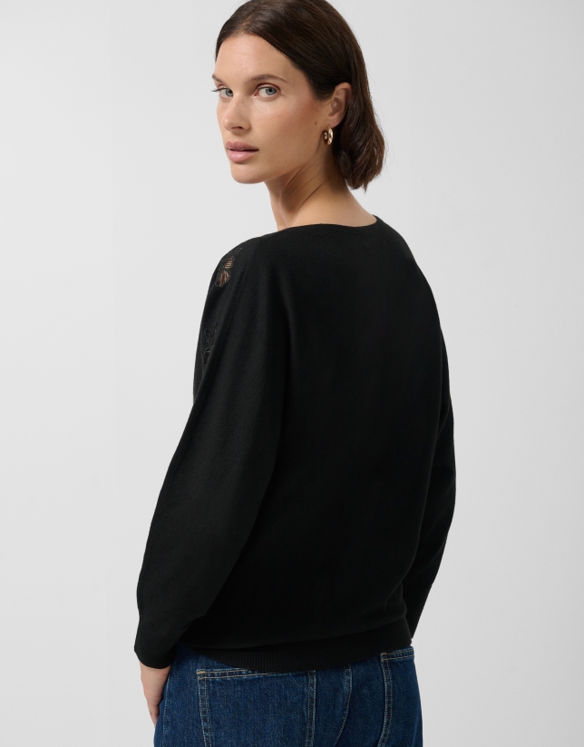 Black fine knit sweater with embroidered lace flowers on the sleeves